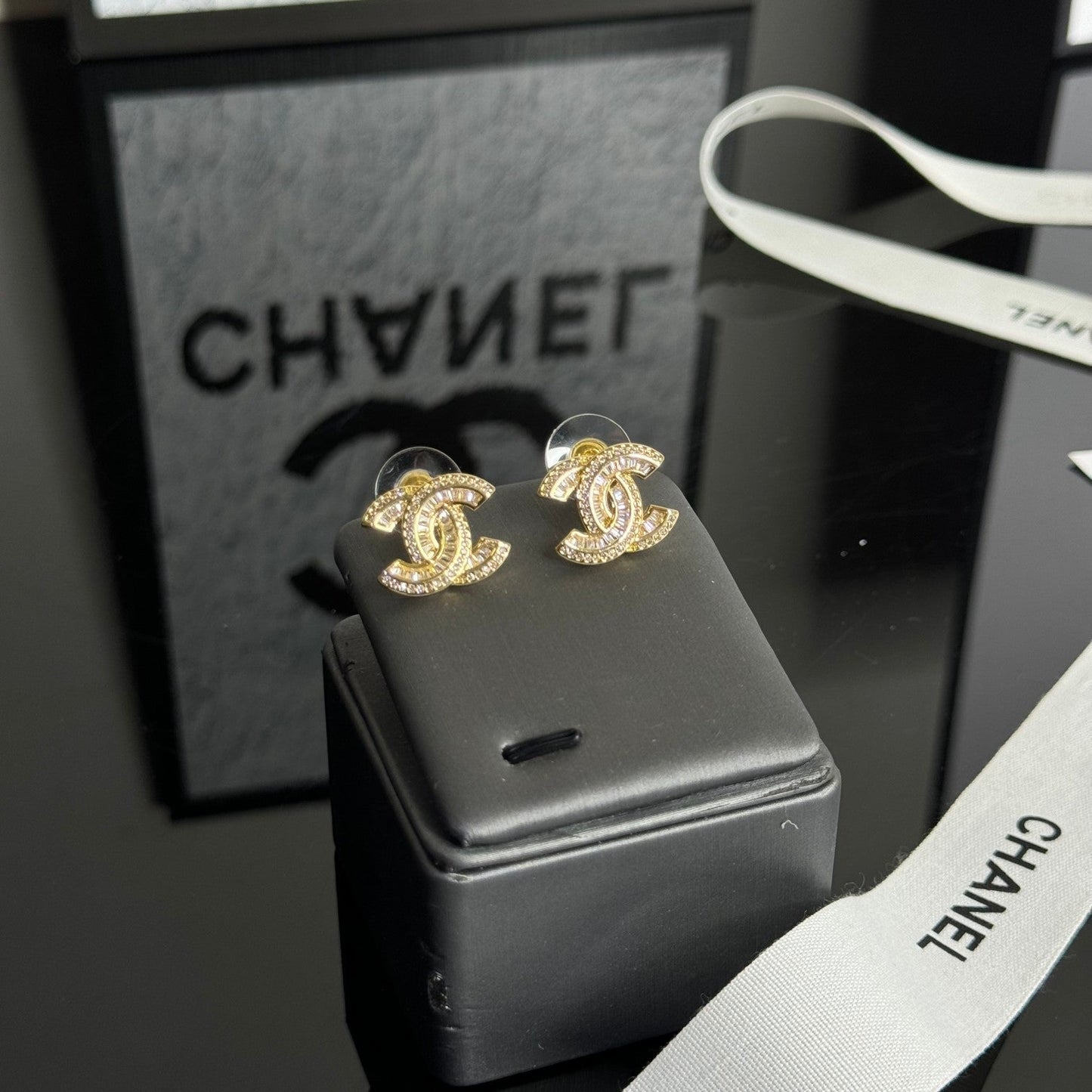 Elegante Ohrstecker mit Strass-Logo